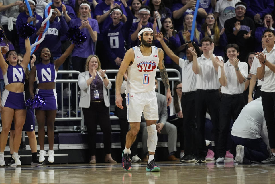 Northwestern guard Boo Buie receives a standing ovation after setting the Northwestern career scoring record during the first half of the team's NCAA college basketball game against Michigan, Thursday, Feb. 22, 2024, in Evanston, Ill. (AP Photo/Erin Hooley)