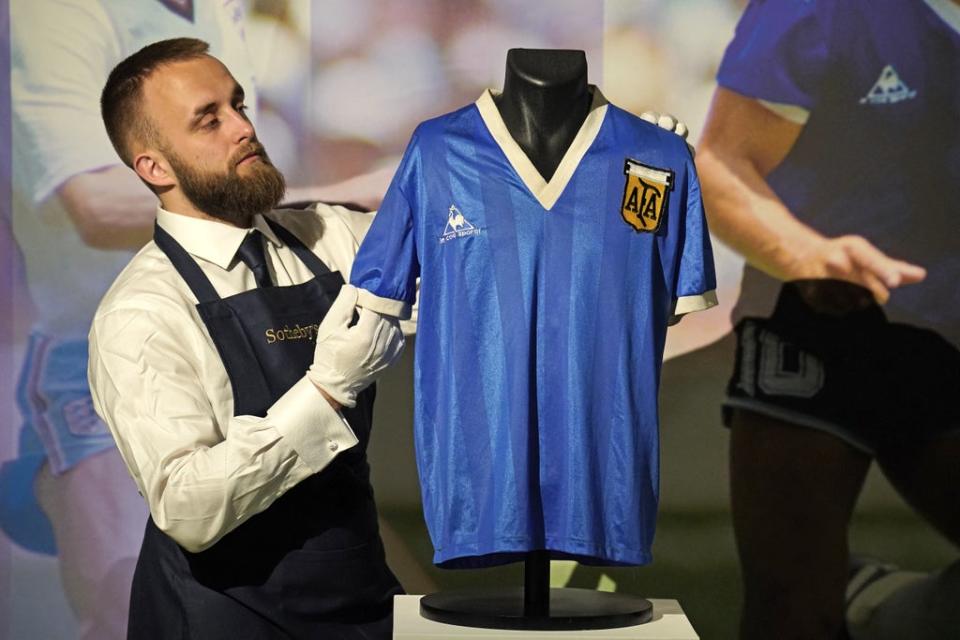 A Sotheby’s gallery assistant with Diego Maradona’s 1986 World Cup Hand of God shirt (Jonathan Brady/PA) (PA Wire)