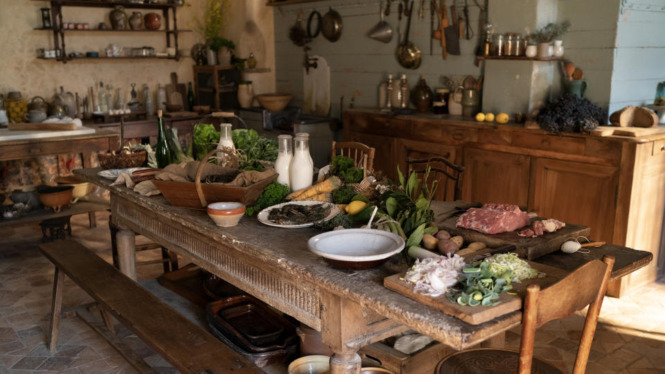 The kitchen table groaning with fresh country vegetables and meats in “The Taste of Things”