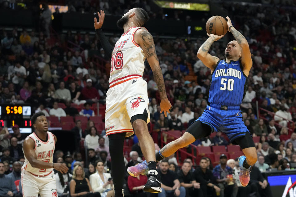 Orlando Magic guard Cole Anthony (50) attempts a basket as Miami Heat forward Caleb Martin (16) defends during the first half of an NBA basketball game, Friday, Jan. 27, 2023, in Miami. (AP Photo/Lynne Sladky)