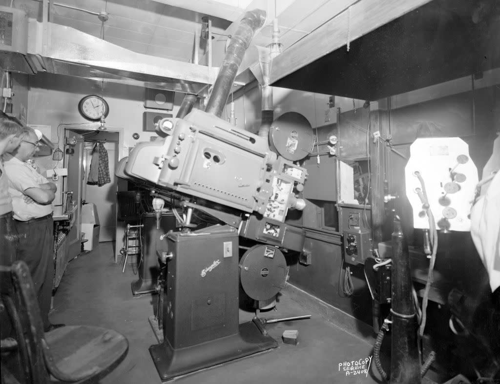 RCA Artcraft and IPC Simplex Cinemascope projector equipment in projection room with operators, at the Orpheum Theatre, 216 State Street, Madison, Wisconsin, February 23, 1954.