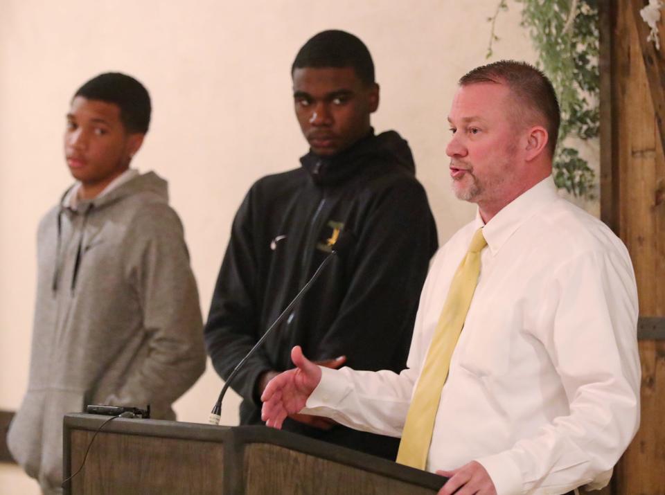 Firestone players Lamar Dampier and Johnathan White listen to Falcons boys basketball coach Brian Neugebauer speak at the Akron Public Schools City Series Basketball Media Day at Guy's Party Center in Akron on Tuesday.