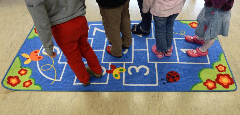 Preschool children stand on a mat to play hopscotch at a kindergarten, in Eichenau, near Munich, southern Germany, on October 9, 2013