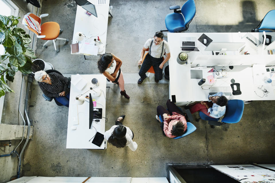 Overhead view of design team having project meeting in office. Photo: Getty