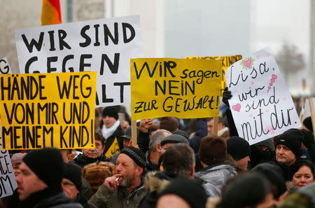 FILE PHOTO: Activists and supporters of the 'International Convention of German Russians' protest against sexual harassment by migrants in front of the Chancellery in Berlin, Germany, January 23, 2016. The placards read 'Hands off from me and my child!', 'We say NO to violence' and 'Lisa, we are with you.' REUTERS/Hannibal Hanschke