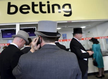 Racegoers queue to place bets during the first day of the Royal Ascot horse racing festival at Ascot in southern England, in this June 18, 2013 file photo. REUTERS/Toby Melville/Files