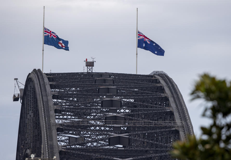 Flags fly at half-staff on the Sydney Harbour Bridge in Sydney as a tribute to Prince Philip, Saturday, April 10, 2021. Buckingham Palace officials say Prince Philip, the husband of Queen Elizabeth II, has died. He was 99. Philip spent a month in hospital earlier this year before being released on March 16 to return to Windsor Castle. (AP Photo/Mark Baker))