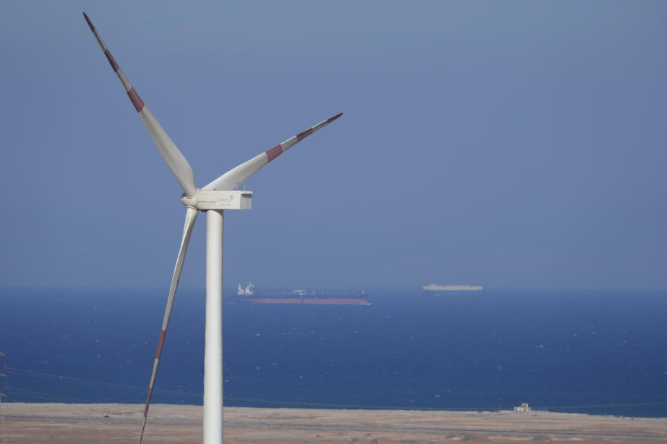 FILE - Cargo ships sail past Lekela wind power station near the Red Sea city of Ras Ghareb, Egypt, Oct. 12, 2022. The Arab world’s most populous country is taking steps to convert to renewable energy. But the developing country, like others, faces obstacles in making the switch (AP Photo/Amr Nabil, File)