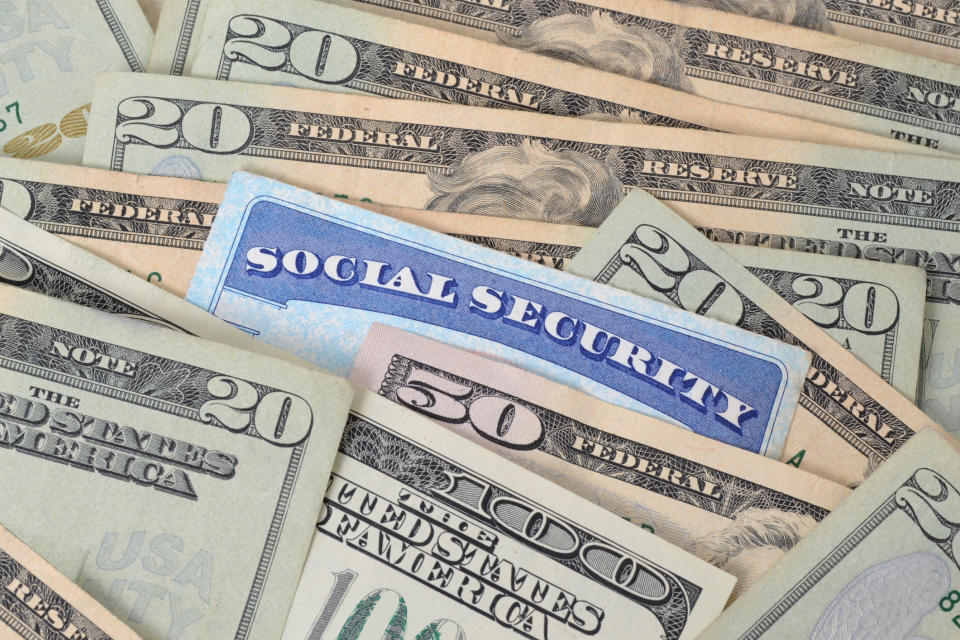 Social Security card sticking out in a pile of bills