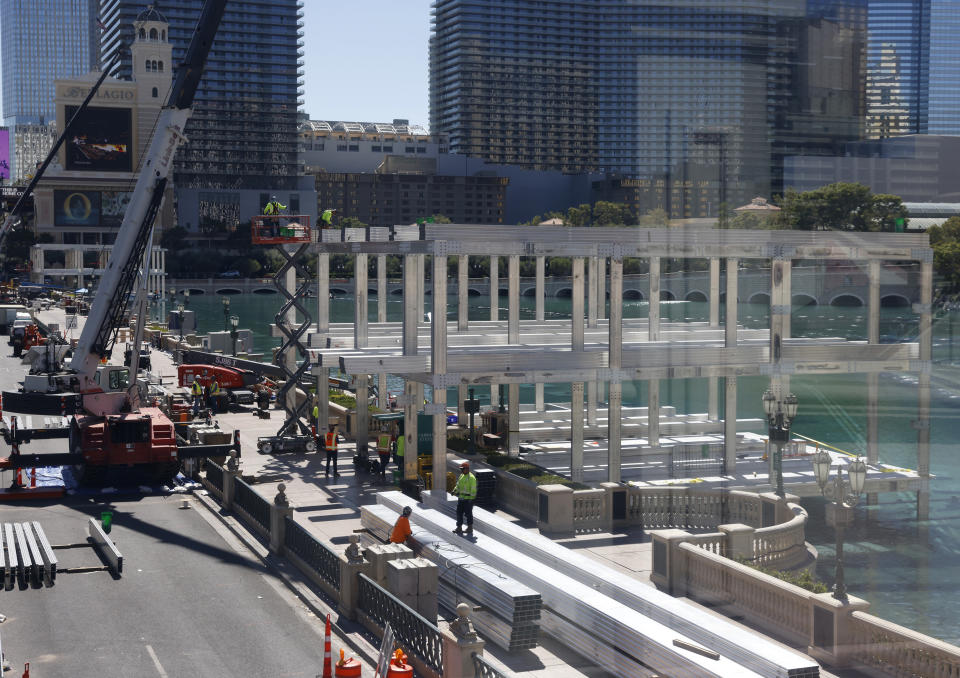 FILE - Workers stand at a Formula One construction site at the Bellagio fountains on Monday, Sept. 25, 2023, in Las Vegas. American Express on Monday announced a multi-year partnership with Formula One in the first new sports sponsorship in more than a decade for the global payment company. F1 races this weekend at Circuit of the Americas in Austin, in Mexico City the next weekend and then Brazil before the inaugural Las Vegas Grand Prix in November. (Bizuayehu Tesfaye/Las Vegas Review-Journal via AP)