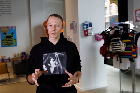 Artist WhIsBe speaks during an interview about his art installation titled "Back to School Shopping" that illustrates the dangers of gun violence in schools, at a gallery in New York City