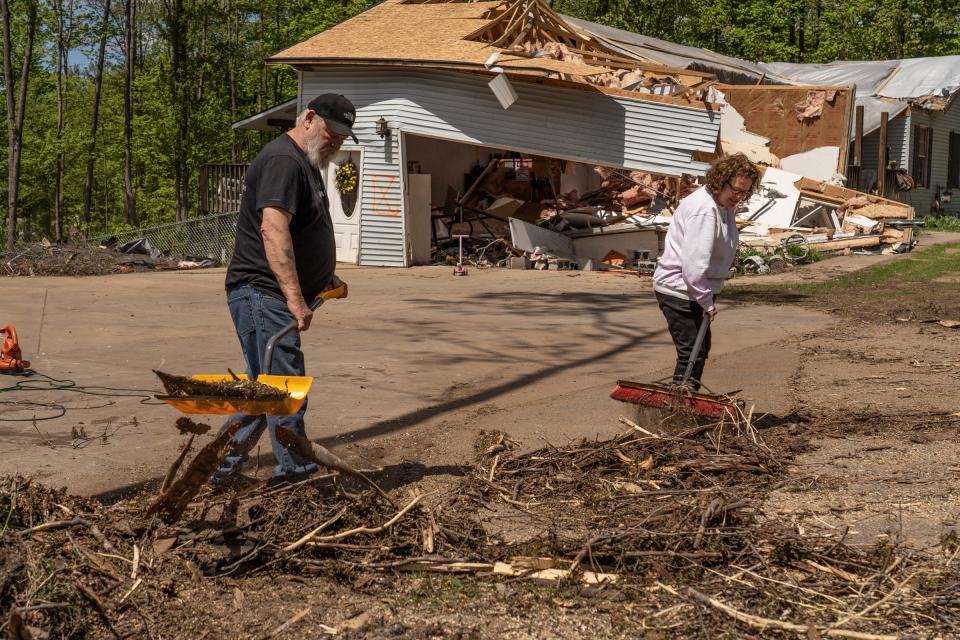 Ernie Wcisel of Gaylord and his wife Jackie Wcisel clear debris from the driveway of their home that was damaged on Shady Brook Lane in on Monday, May 23, 2022, following the EF-3 tornado moved through the area destroying many homes and businesses in Gaylord.