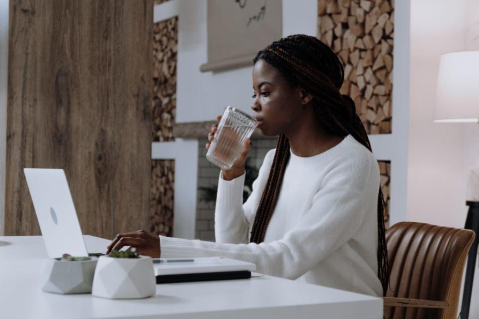 Black woman drinking a glass of water for weight loss