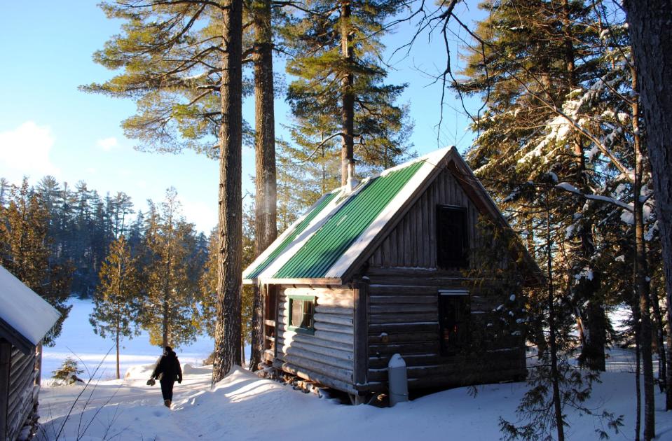 This December 2012 photo shows a rustic cabin in the snow at the Appalachian Mountain Club’s Gorman Chairback Lodge, a backcountry wilderness lodge near Greenville, Maine. In winter, visitors can reach the lodges and cabins only by cross-country skiing in. (AP Photo/Lynn Dombek)