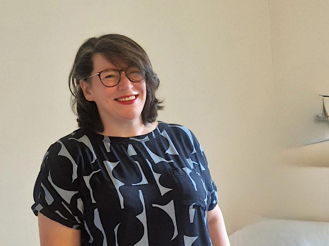 Georgina Bruce wearing glasses and a printed top and smiling.