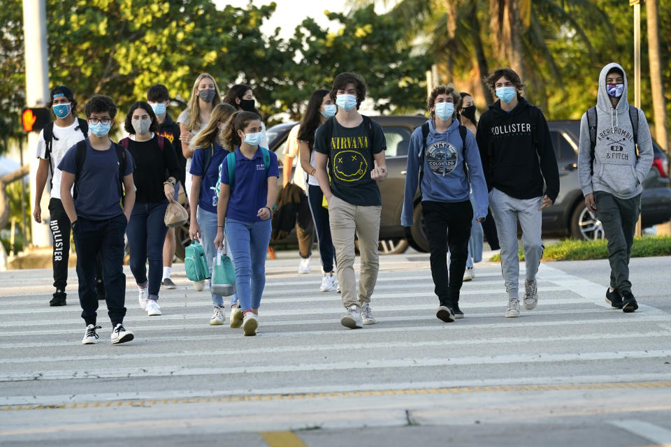 Students arrive for classes at Mast Academy, Tuesday, Oct. 13, 2020, in Miami. The maritime and science technology magnet high school was closed for one day this week after two students reported having the COVID-19 virus. (AP Photo/Lynne Sladky)