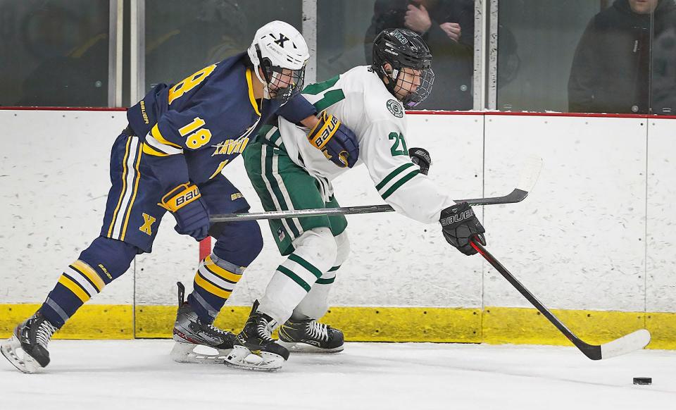 Xaverian Taejun Tow tries to get the puck from Marshfield's #21Teddy Devoe.Marshfield hosted Xaverian in boys hockey at The Bog in Kingston on Thursday February 23, 2023 