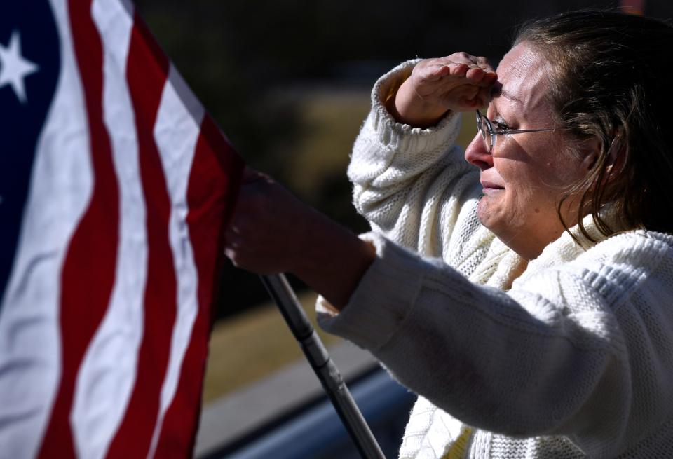 Angela Maltby holds an American flag and salutes from Eastland's South Bassett Street bridge as the funeral procession for fallen Eastland Sheriff's Deputy Barbara Fenley passes beneath her on Interstate 20 on March 23. On the same bridge, members of the Eastland Fire Department had extended a ladder with their own flag hanging down to honor Fenley.