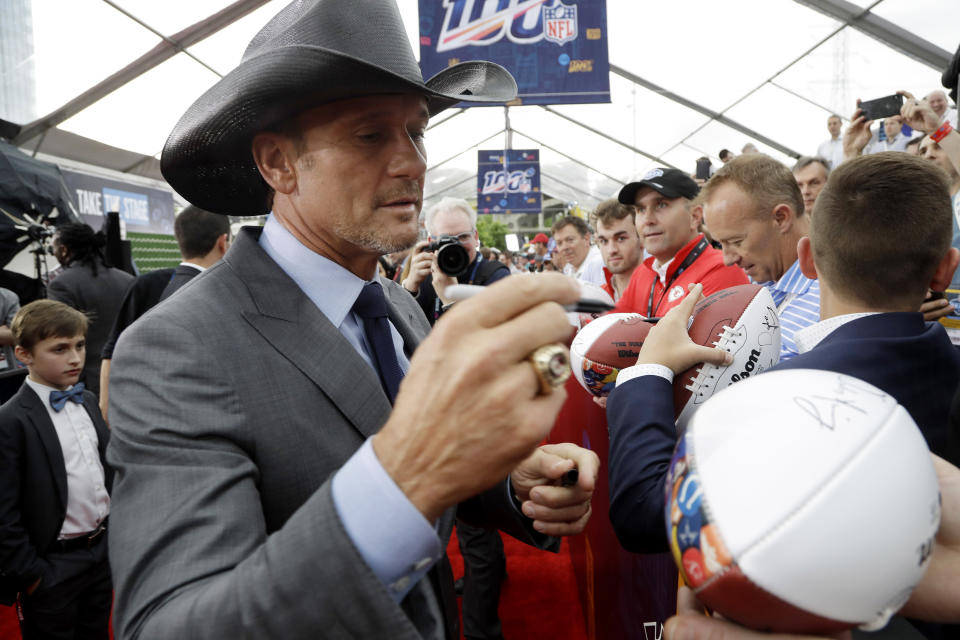 FILE - Country music star Tim McGraw signs an autograph as he walks the red carpet ahead of the first round at the NFL football draft on April 25, 2019, in Nashville, Tenn. McGraw turns 54 on May 1. (AP Photo/Steve Helber, File)