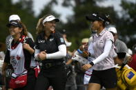 Canada's Brooke Henderson, center, and New Zealand's Lydia Ko, right, laugh as they walk on the fairway during the first round of the CP Women's Open golf tournament, Thursday, Aug. 25, 2022, in Ottawa, Ontario. (Justin Tang/The Canadian Press via AP)