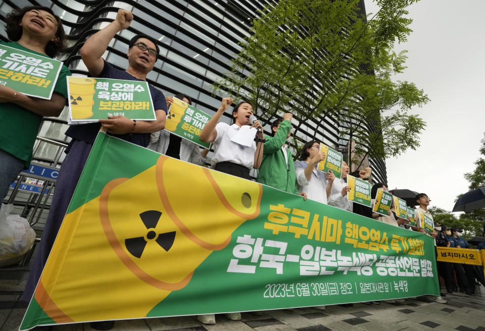 Environmental activists protest against the Japanese government's decision to release treated radioactive wastewater from the wrecked Fukushima nuclear power plant, near a building which houses the Japanese Embassy in Seoul, South Korea, Friday, June 30, 2023. The signs read, "Oppose to release treated radioactive water from the Fukushima." (AP Photo/Ahn Young-joon)