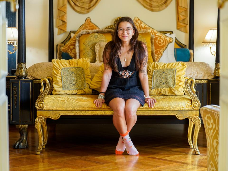 The author sits on the bench in the Aurora Suite in the former Versace Mansion