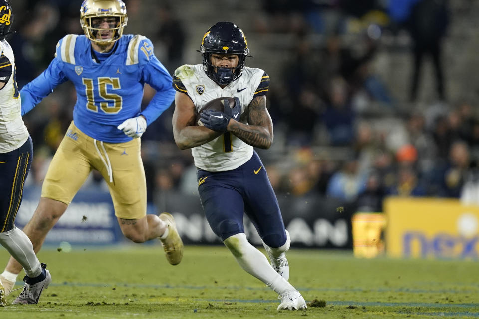 California running back Jaydn Ott (1) runs the ball as UCLA defensive lineman Laiatu Latu (15) chases during the second half of an NCAA college football game, Saturday, Nov. 25, 2023, in Pasadena, Calif. (AP Photo/Ryan Sun)