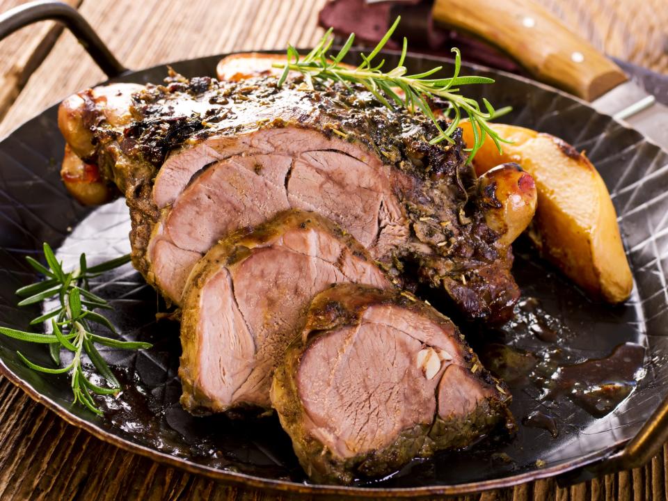 leg of lamb with herbs on a black serving dish