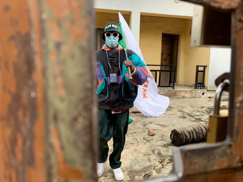 Adebanjo Akinwunmi holds his flags as Nigeria marks the first anniversary of the EndSARS anti-police brutality protests in Lagos