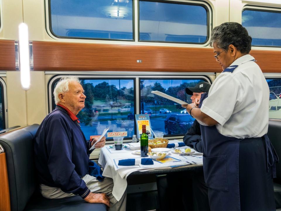 A man ordering a meal in an Amtrak dining car.