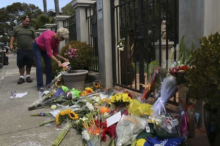 A woman places flowers and a card outside the home of actor Robin Williams in Tiburon, California August 12, 2014. REUTERS/Robert Galbraith