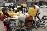 Yemeni boys upload a cart with jerrycans to fill them with water from a public tap amid an acute shortage of water supply to houses in Sanaa, on April 26, 2015