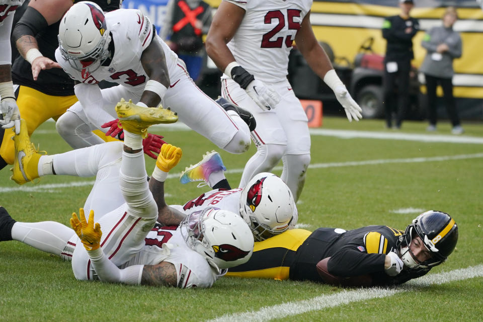 Pittsburgh Steelers quarterback Kenny Pickett, right, is stopped just short of the endzone by Arizona Cardinals safety Budda Baker, Cardinals linebacker Josh Woods, left, and Cardinals defensive end Jonathan Ledbetter during the first half of an NFL football game, Sunday, Dec. 3, 2023, in Pittsburgh. (AP Photo/Gene J. Puskar)