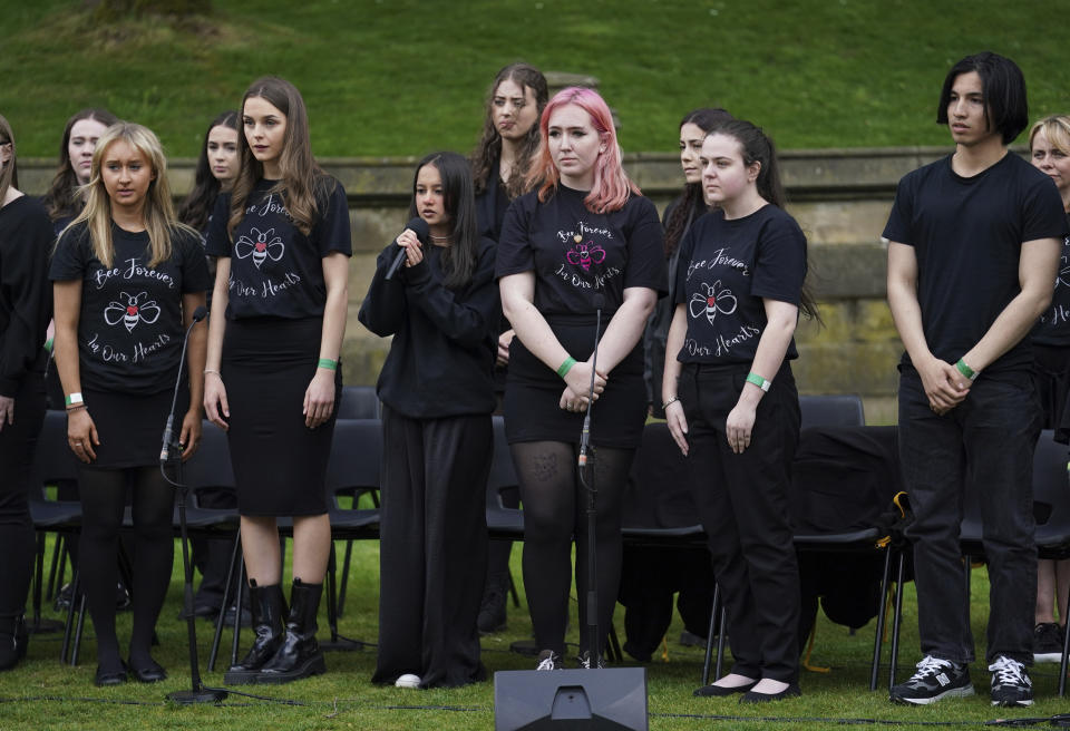 Miembros del Coro de Sobrevivientes de Manchester y el Coro de la Escuela Secundaria Parrs Wood cantan durante la inauguración del monumento Glade of Light afuera de la Catedral de Manchester, en memoria de las víctimas de un ataque suicida en un concierto de 2017 de Ariana Grande, el martes 10 de mayo de 2022 en Manchester, Inglaterra. (Foto AP/Jon Super)