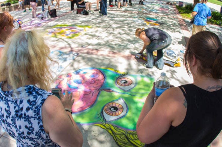 Spectators look on as a chalk artist completes a project during a past Chalk It Up Amarillo College art contest.