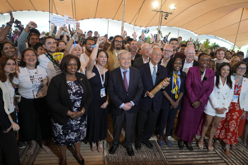 United Nations Secretary-General Antonio Guterres, center, Portuguese President Marcelo Rebelo de Sousa, center right, and actor Jason Momoa, behind Guterrs, pose with participants at the United Nations' Youth and Innovation Forum at Carcavelos beach, outside Lisbon, Sunday, June 26, 2022. From June 27 to July 1, the United Nations is holding its Oceans Conference in Lisbon expecting to bring fresh momentum for efforts to find an international agreement on protecting the world's oceans. (AP Photo/Armando Franca)
