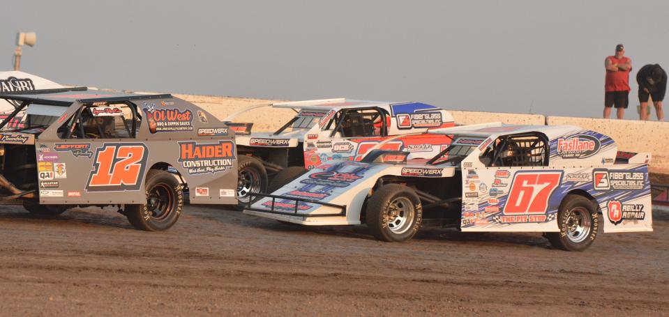 Watertown drivers Logan Redlin (12), Mike Nichols (67) and Tommy Nichols (top) battle for position in a Midwest modified heat race during the season-opening racing program on Sunday, May 12, 2024 at Casino Speedway in Watertown.