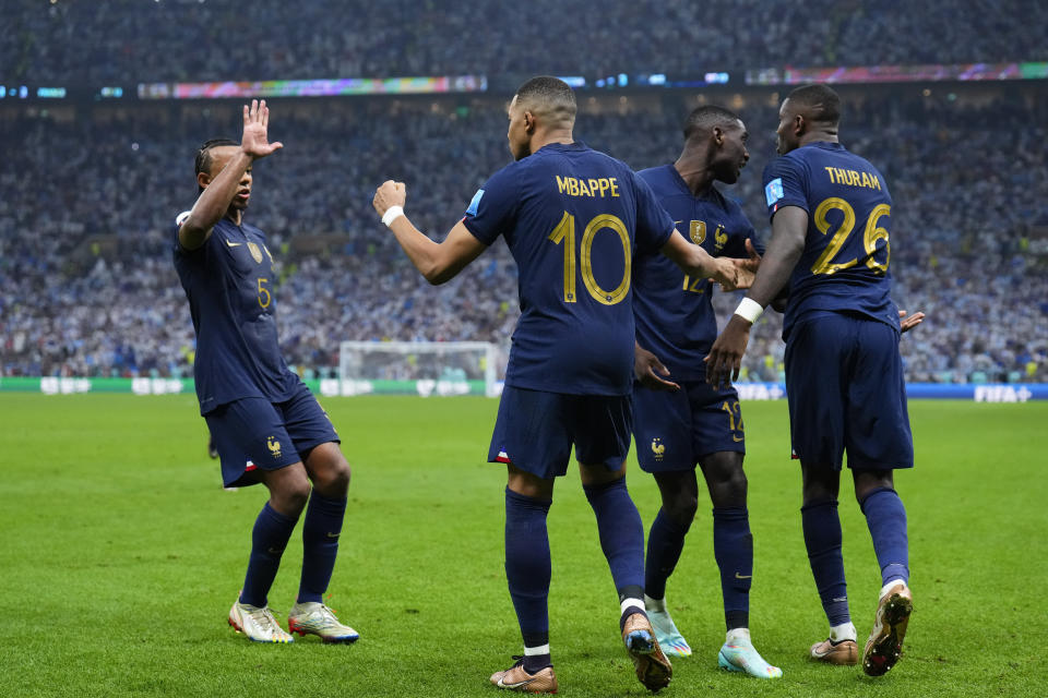 France's Kylian Mbappe celebrates with teammates scoring from the penalty spot his side's third goal during the World Cup final soccer match between Argentina and France at the Lusail Stadium in Lusail, Qatar, Sunday, Dec. 18, 2022. (AP Photo/Natacha Pisarenko)