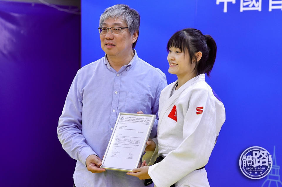 柔道總會主席黃寶基（左）向嘉莉頒發「奧運資格確認證書」。