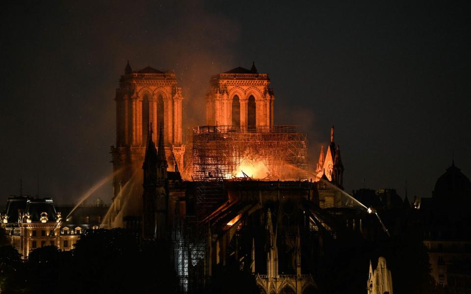 Firefighters doused flames rising from the roof of the cathedral on April 15, 2019 - BERTRAND GUAY/AFP