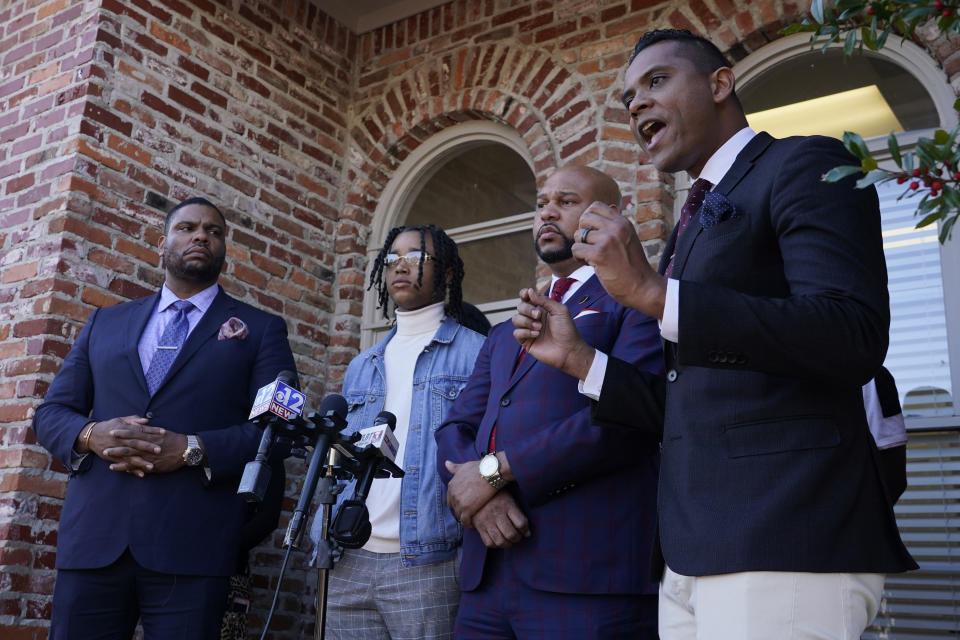 FedEx driver Demonterrio Gibson, second from left, stands with his legal team of attorneys, Rodney S. Diggs, left, Carlos Moore, second from right, as they listen to a James A. Bryant II, also a lawyer and member of their legal team, speak during a news conference in Ridgeland, Miss., Thursday, Feb. 10, 2022. Gibson and his attorneys say the delivery driver was shot at by a white father and son in Brookhaven and that both suspects have been "undercharged" and should face charges of attempted murder and hate crimes. (AP Photo/Rogelio V. Solis)