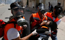 <p>A female Palestinian medic is evacuated after inhaling tear gas fired by Israeli forces during a protest against the U.S. Embassy’s move to Jerusalem and ahead of the 70th anniversary of Nakba, near Ramallah in the occupied West Bank on May 14, 2018. (Photo: Mohamad Torokman/Reuters) </p>