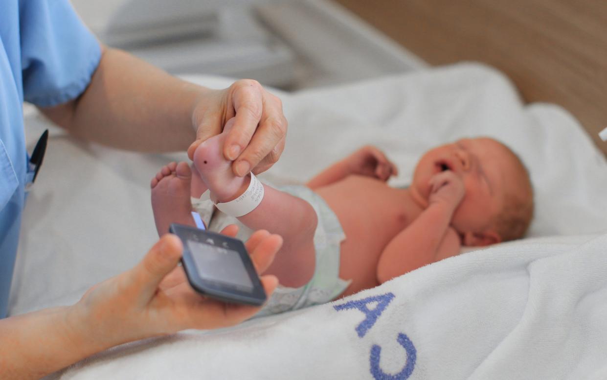 Doctor conducts baby blood test