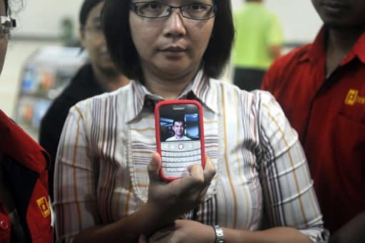 Yanny Meriana shows a photograph of family friend Edward Pangabean, who was a passenger on the ill-fated Russian Sukhoi Superjet 100, at the arrival area of Halim airport in Jakarta. A Russian Sukhoi Superjet 100 with about 50 people on board went missing in a mountainous area south of the Indonesian capital Jakarta during a demonstration flight Wednesday, officials said