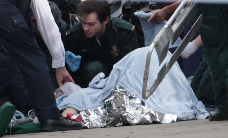 An injured person is treated at the sight of the London terror attack. Photo: AAP