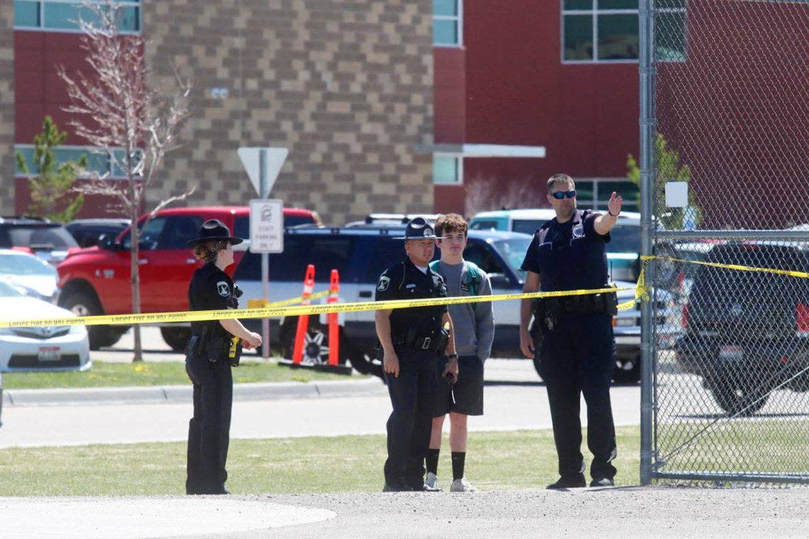 Police stand with a youth outside Rigby Middle School following a shooting there on May 6, 2021.