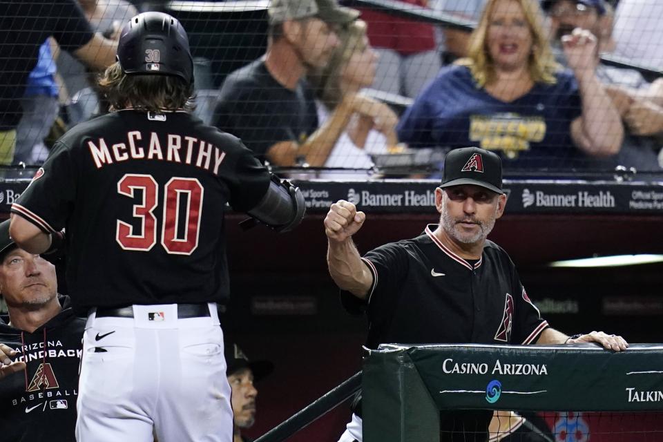 Arizona Diamondbacks' Jake McCarthy (30) celebrates his home run against the Philadelphia Phillies with manager Torey Lovullo, right, during the fourth inning of a baseball game Wednesday, Aug. 31, 2022, in Phoenix. (AP Photo/Ross D. Franklin)