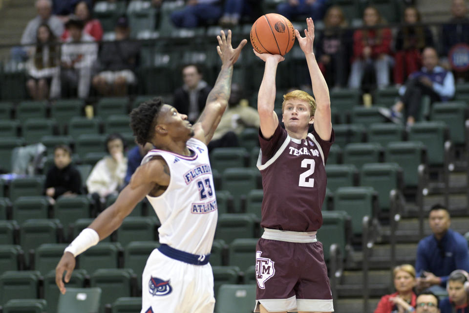 Texas A&M guard Hayden Hefner (2) shoots a 3-pointer as Florida Atlantic guard Brandon Weatherspoon (23) defends during the first half of an NCAA college basketball game, Friday, Nov. 24, 2023, in Kissimmee, Fla. (AP Photo/Phelan M. Ebenhack)