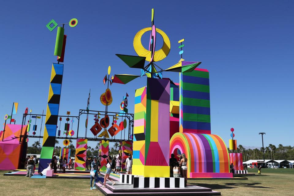 People gather near the art installation titled "Dancing in the Sky" by artist London-based Morag Myerscough during the Coachella Music and Arts Festival in Indio, Calif., on Friday, April 12, 2024.
