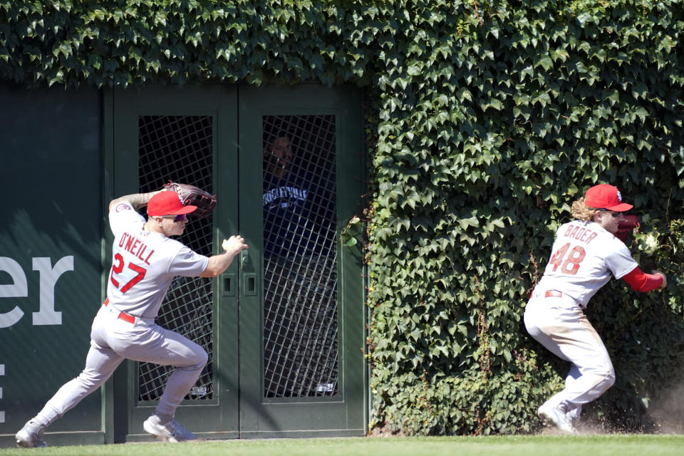 St. Louis Cardinals left fielder Tyler O'Neill (27) and center fielder Harrison Bader (48) can't catch a three-run double hit by Chicago Cubs' Kris Bryant (17) during the seventh inningof a baseball game, Friday, July 9, 2021, in Chicago. (AP Photo/David Banks)